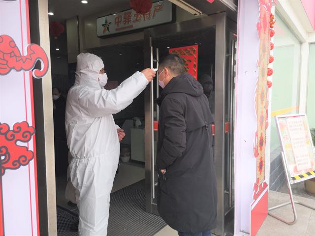 釜山服务区阮忠斌正在给旅客测量体温.jpg